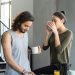 A couple enjoying a cozy breakfast with coffee and juice in their modern home kitchen.